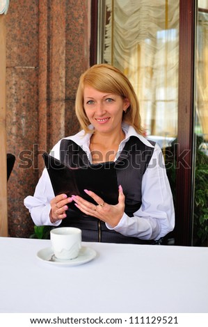 woman sitting in restaurant, with receipt and wallet on the table