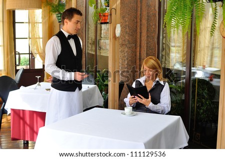 A young and attractive woman paying the bill in a restaurant