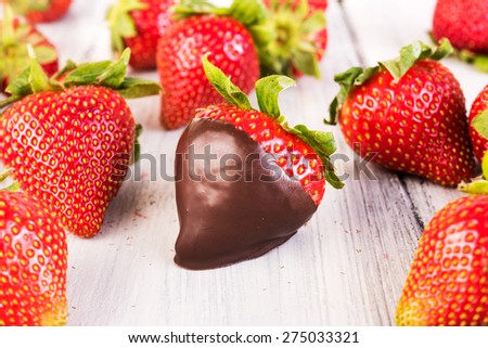 Strawberry in chocolate. Melted Chocolate pouring on fresh ripe juicy strawberry close up. Dessert. Gourmet food. Fondue