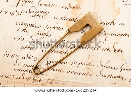 Vintage brooch or safety pin on letter background,