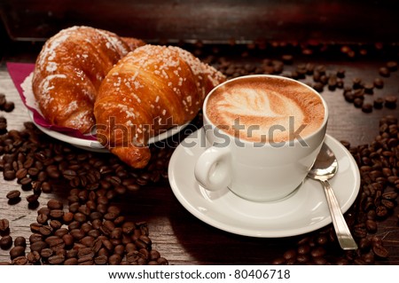Cappuccino and croissant with coffee bean