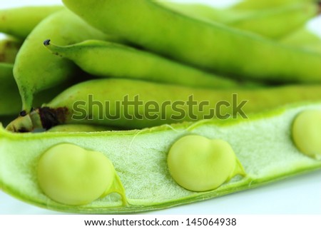 broad bean pods and beans on white background .