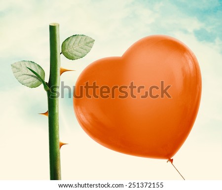Rose thorn about to pop love heart balloon in vintage blue sky, clipping path and alpha channel included.