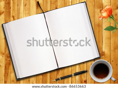 blank opened book outdoors on wooden disk Pen, flower and cup of tea.
