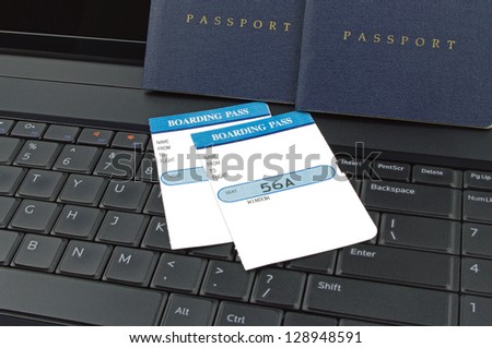 two passports and boarding cards on computer