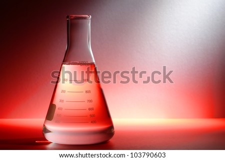 Scientific laboratory glass conical Erlenmeyer flask filled with clear chemical liquid for a chemistry experiment in a science research lab