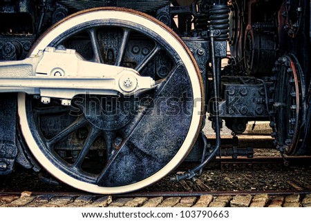 Old steam locomotive vintage running gear with driving wheel and rods assembly in grunge industrial