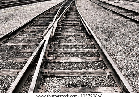 Railroad tracks right of way rail lanes and train switch on traditional railway wood ties over gravel ballast