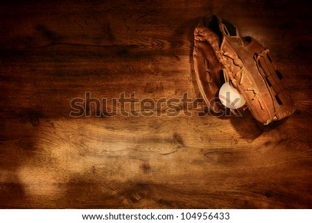 Old worn leather baseball glove and used ball on nostalgic Americana sport wood plank background