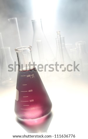 Scientific laboratory glass conical Erlenmeyer flask filled with cold chemical liquid for a cryogenic chemistry experiment in a science research lab with frozen vapors and freezing steam fog