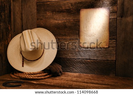 American West rodeo cowboy white straw hat and authentic western rope lasso on weathered wood floor in an old ranch barn with aged antique poster notice on wall