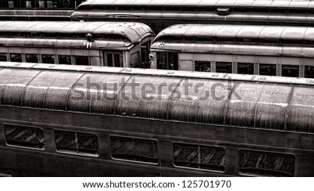 Vintage rail passenger transportation cars lined up in an old railroad train station with vintage finish