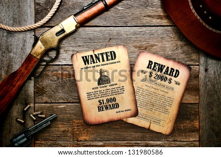American west legend old west wanted sheriff poster and dead or alive search reward Marshall notice on antique wood desk with rifle shotgun and revolver with bullets ( documents created by author)