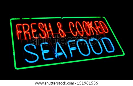 Fresh and cooked seafood old and dusty vintage fluorescent neon store sign at a fish market