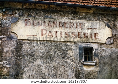 Boulangerie and patisserie French antique bakery and pastry shop old and distressed store sign hanging on a derelict grunge wall of an ancient and damaged building in a small rural town in France