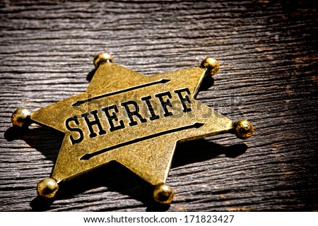 American West Legend Law Enforcement Officer Antique Sheriff Deputy Star Shape Gold Color Brass Badge As Vintage Western Lawman Identification And Prestige Shield On Old Frontier Jail Office Table