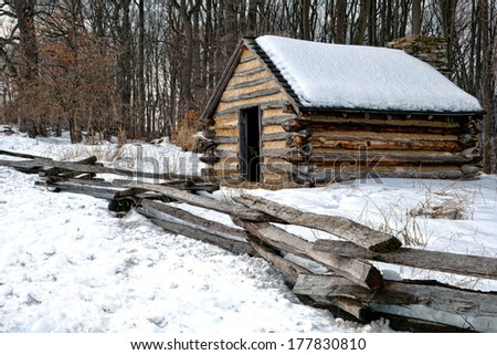 American Revolutionary War housing cabin with wooden fence in an encampment in winter snow at Valley Forge National Historical Park military camp of the Continental Army near Philadelphia Pennsylvania