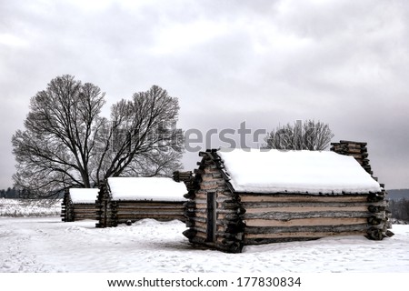 American Revolutionary War soldier housing wood log cabins in encampment in winter snow at Valley Forge National Historical Park military camp of the Continental Army near Philadelphia in Pennsylvania