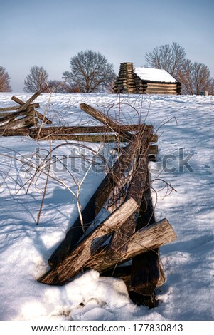 Split rail fencing enclosure fence and American Revolutionary War cabin in winter snow at Valley Forge National Historical Park military camp of the Continental Army near Philadelphia in Pennsylvania