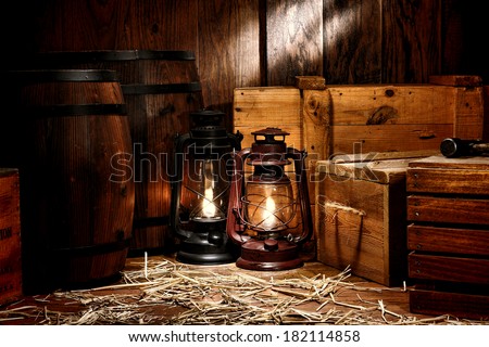 Old fashioned light kerosene lantern style oil lamps in antique shipping warehouse stockroom with vintage wooden crates containers and ancient storage boxes near retro whiskey transportation barrels