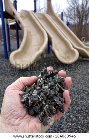 Shredded and cut pieces of used recycled automobile rubber tire crumb reused as soft surface ground floor filler mulch compound on children amusement playground for safety and injury prevention
