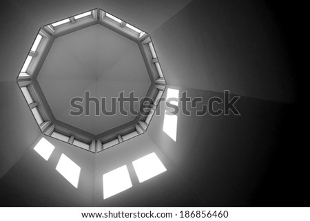 Interior building architectural design detail octagon roof turret ceiling top with windows and light projections above viewed from below inside