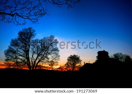 American Revolutionary War soldier housing wood cabin encampment house and trees silhouette at sunset at Valley Forge National Historical Park military camp  near Philadelphia in Pennsylvania
