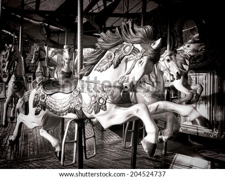 Antique style carved wood nostalgic carousel riding horse with vintage decorations on an old amusement merry go round carnival ride