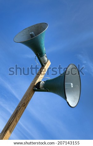 Outdoor public announcement communication system loudspeakers with horn speakers electronic sound amplification device mounted on a wood pole broadcasting a message at an event grounds
