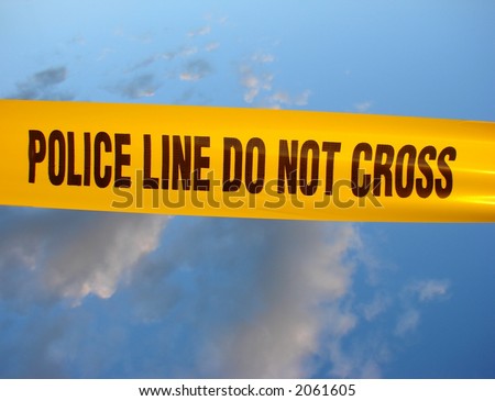 Police line do not cross yellow warning tape over blue sky