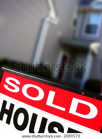 Real estate sold rider insert on a realtor advertising sign in front of a house for sale