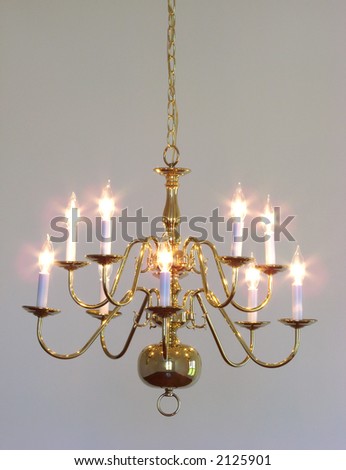 Traditional style home dining room brass chandelier light fixture with clear flame bulbs hanging from ceiling