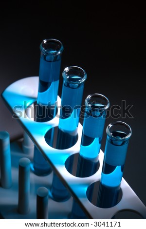 Laboratory glass test tubes filled with blue liquid on a rack for an experiment in a science research lab