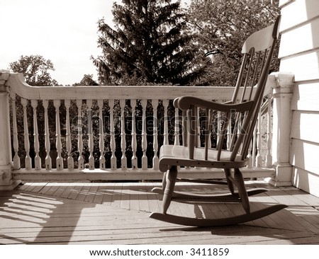 Rocking chair on an old house porch in nostalgic sepia