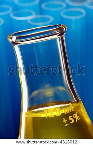 Scientific laboratory glass conical Erlenmeyer flask filled with yellow chemical liquid for a chemistry experiment in a science research lab