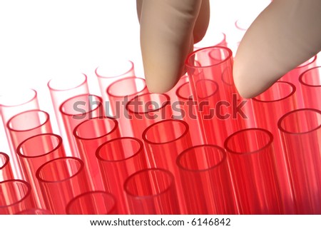 Scientist hand holding a laboratory plastic test tube with other red tubes in a rack of red chemistry tubes for an experiment in a science research lab