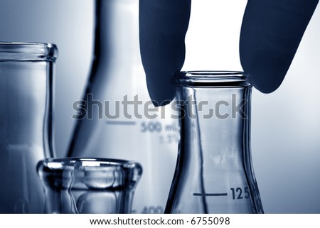 Scientist hand holding a laboratory glass conical Erlenmeyer flask for an experiment in a science research lab