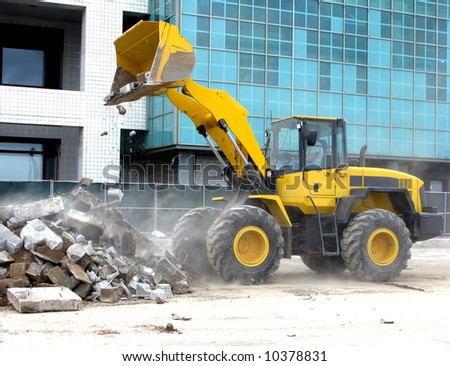 Front loader unloading concrete rubble on an urban construction work site