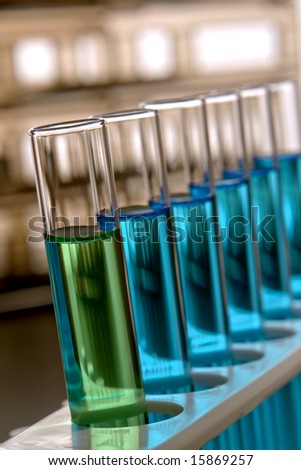 Laboratory glass test tubes filled with green and blue liquid on a rack for an experiment in a science research lab