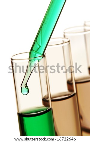Laboratory pipette with drop of green liquid inside glass test tubes for an experiment in a science research lab