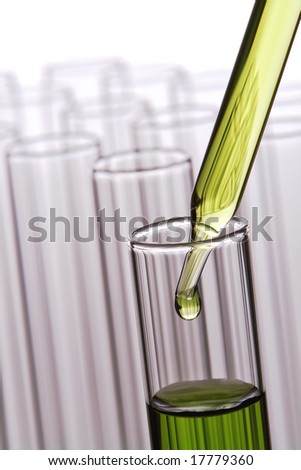 Laboratory pipette with drop of green liquid inside a test tube for an experiment in a science research lab over white background