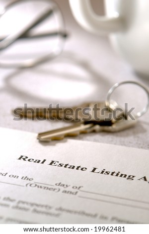 Real estate brokerage home listing contract agreement and set of house keys on a kitchen table