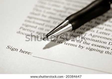 Ballpoint ink pen on the sign here line of a legal contract ready to be signed(fictitious document with authentic legal language)