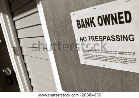 Real estate lender bank owned no trespassing sign notice posted on the boarded up window of a vacant house in repossession foreclosure (fictitious document with authentic legal language)