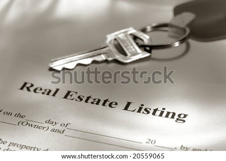 Real estate broker residential house sale listing contract paperwork and key on a Realtor desk
