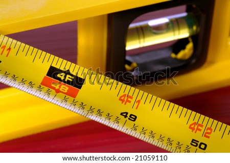Construction bubble spirit level and retractable tape measure with inch and foot measurement markings
