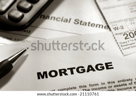 Real estate lender home mortgage loan application form with W2 tax statement and calculator over a bank financial statement for borrower financing verification and qualification