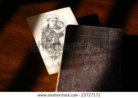 Antique religious lithograph image print of a saint holding a child inside an old prayer book