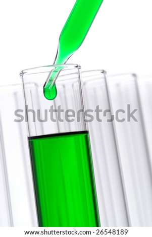 Laboratory pipette with drop of green liquid over test tubes for an experiment in a science research lab