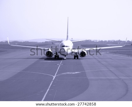 Commercial passenger jet taxiing on an airport runway before take off or after landing